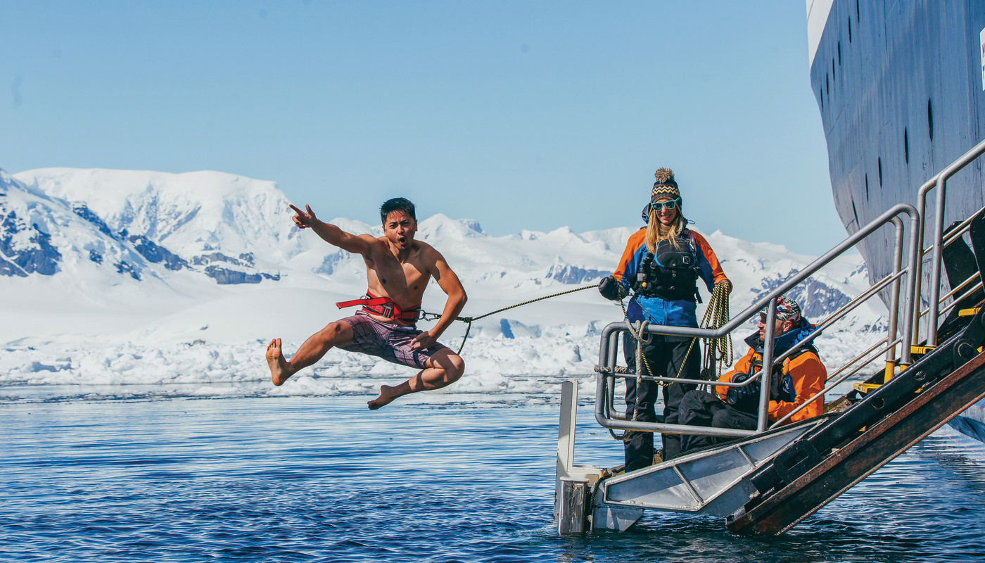 A guest jumps off the gangway (with a safety harness) into Antarctic waters during the Polar Plunge.