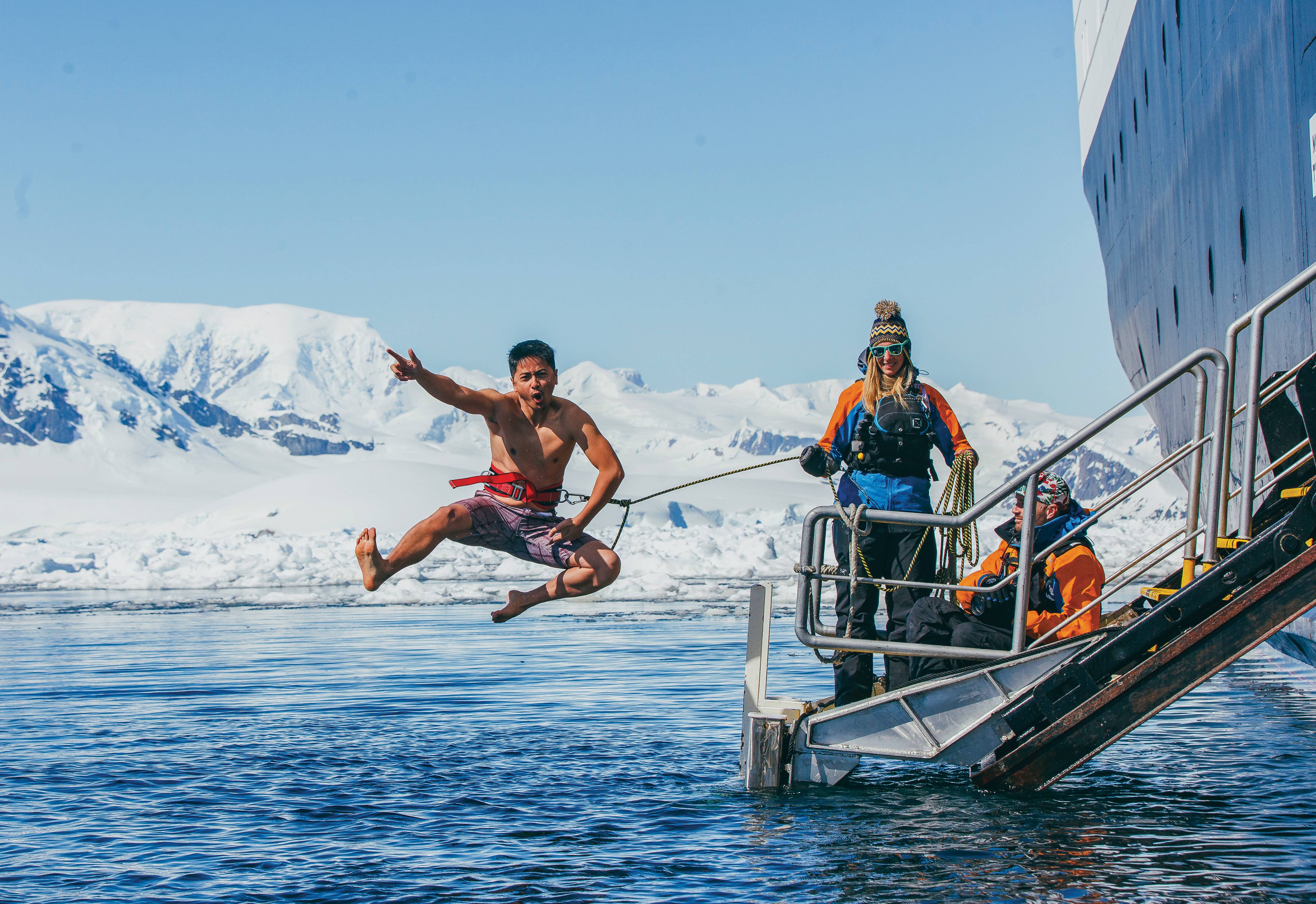 A guest jumps off the gangway (with a safety harness) into Antarctic waters during the Polar Plunge.