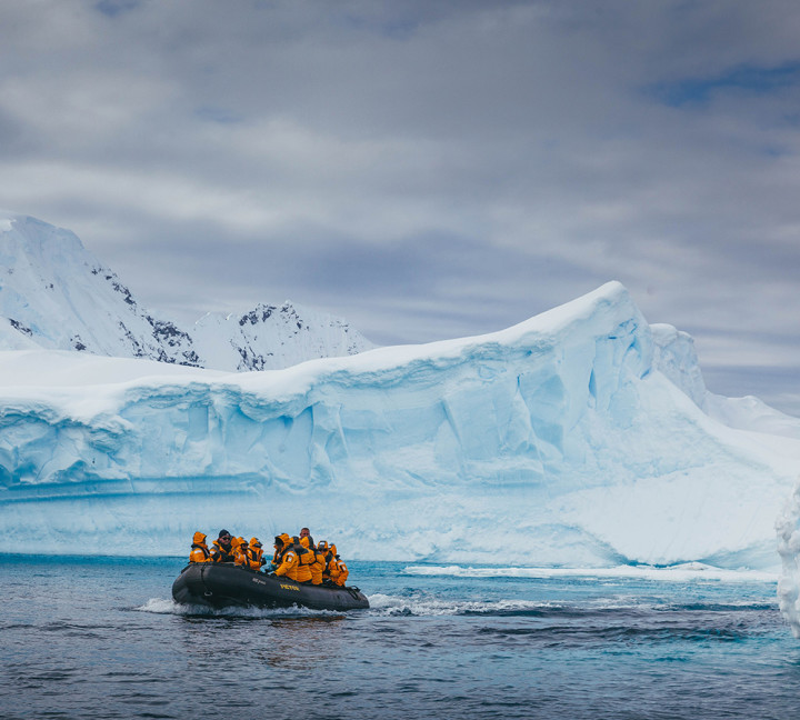Guests zodiac cruise near an iceberg on one of our excursions.