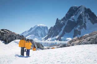 Guests hike through the snow at Petermann Island in the Antarctica Peninsula.